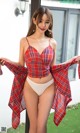 A woman in a red plaid top and white panties posing for a picture.