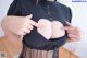 A woman in a black shirt is showing off her big breasts.