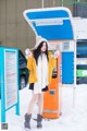 A woman standing in front of a vending machine.