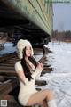 A woman sitting on a train track in the snow.