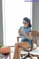 A woman sitting on a chair looking at her phone.