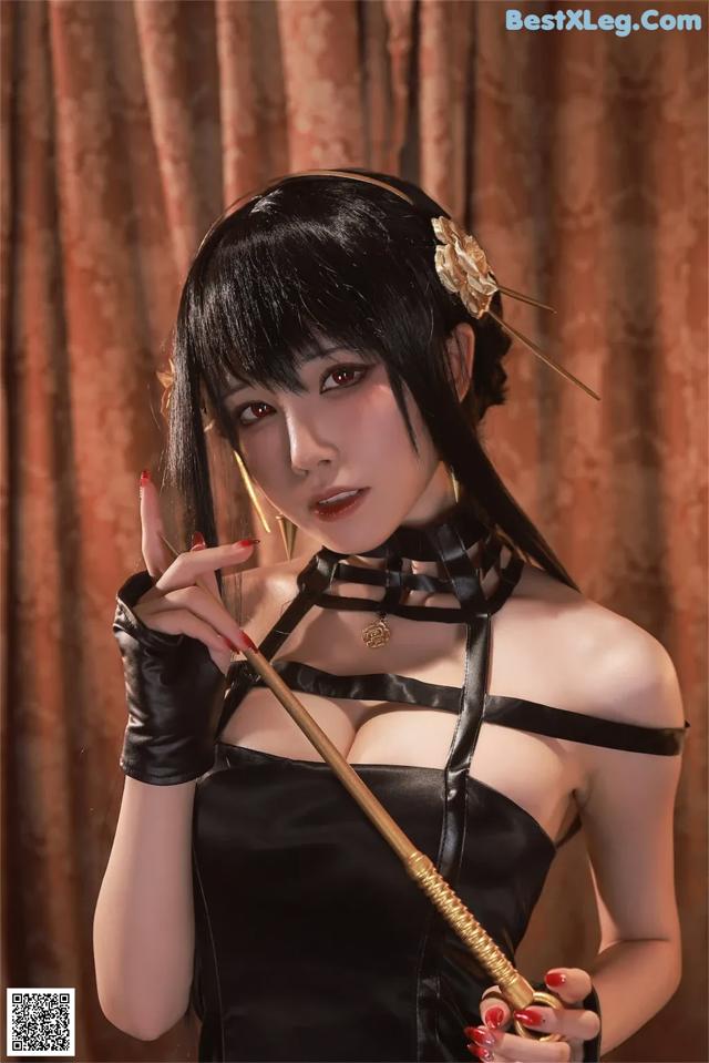 A woman in a black dress holding a sword.