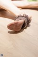 A close up of a woman's feet on a wooden floor.