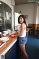 A woman standing in front of a counter with plates of food.