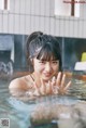 A woman in a hot tub with her hands in the water.