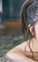 A woman in a hot tub with her back to the camera.