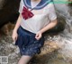 A woman in a sailor outfit standing in a stream.