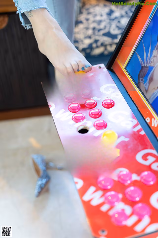 A person is playing a game on an arcade machine.