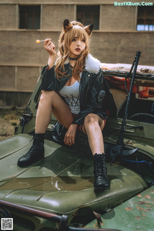 A woman sitting on top of a military vehicle smoking a cigarette.