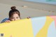 A young girl holding a surfboard on the beach.